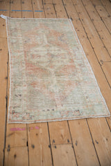 The overall geometric pattern and time-softened colors of a vintage distressed Oushak rug runner.