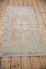 Full perspective of a distressed Oushak runner with time-softened colors and a geometric pattern.