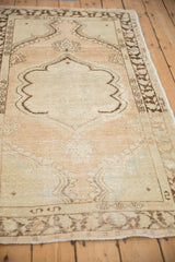 Angled perspective of a distressed Oushak rug showing its scalloped medallion and abrashed field.
