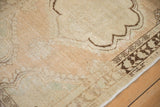 Even wear across the serpent design border and scalloped medallion of a distressed Oushak rug.