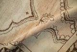 Evenly worn pile and brown scalloped medallion details on a softly folded vintage Oushak rug.