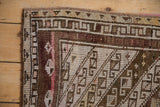 Distressed hand-knotted pile texture featuring chocolate brown, ivory geometric border.