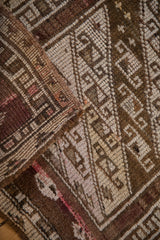 Distressed Kars rug's diagonal geometric pattern and textured pile with soft brown and ivory.
