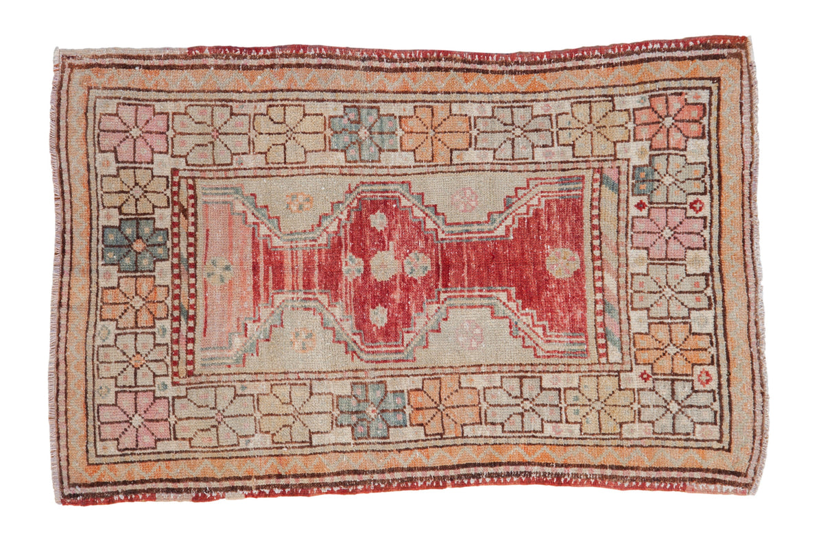 Vintage distressed Oushak rug with a raspberry medallion and playful geometric florals in seafoam and orange.