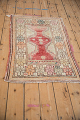A vintage Turkish Oushak rug viewed from an angle, showcasing its colorful geometric floral border.