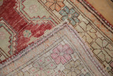Reverse view of the vintage Oushak rug's hand-knotted foundation and secured side cord.