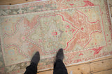 Overhead view of a vintage Oushak rug's shield medallion and soft, distressed pile.
