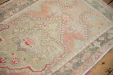 Close-up of the vintage Oushak's main border showing alternating colors and low, even wear.