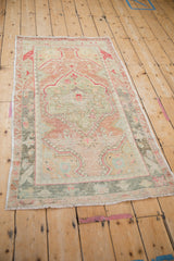 Full perspective view of a distressed Turkish Oushak rug in faded seafoam, silver, and melon tones.