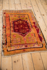 Vintage Oushak rug medallion in black cherry red, tangerine, and gold, showcasing finned floral design.