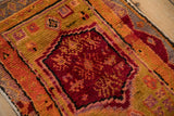 Textured pile of vintage Turkish Oushak rug with black cherry red and orange floral motifs.