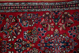 Vintage Sarouk runner's cherry red field with colorful floral sprays and intricate banded border.