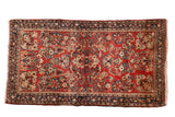 Vintage German Sarouk rug with floral bouquets and sprays on a cherry red field and dark navy borders.