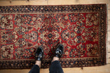Top-down view of the vintage German Sarouk rug's cherry red field with intricate floral sprays.