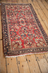 Angled perspective of a vintage German Sarouk rug with a cherry red field of dense floral sprays.