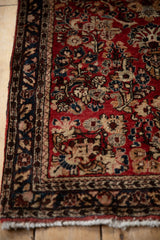 Intricate vine and blossom border in navy and blush on a vintage German Sarouk rug.