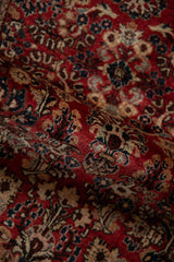 Angled view of a vintage German Sarouk rug's varied pile height and floral sprays.