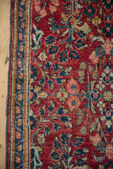 Vintage American Sarouk rug corner showing the cherry red floral field and detailed vine border.