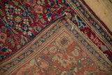 Vintage Sarouk rug corner showing the cherry red pile and hand-knotted back.