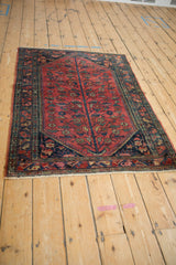 Vintage Lilihan rug's unidirectional tree of life design with raspberry red, vines, and serrated leaves.