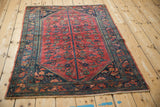 Vintage Lilihan rug corner with intricate navy blue border and raspberry tree-of-life motifs.