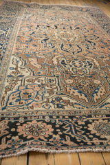 Distressed vintage Heriz carpet texture with faded floral motifs and serrated border design.