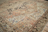 Distressed Heriz carpet, geometric and curvilinear motifs in dusty rose and brown.