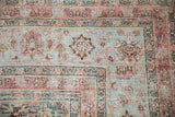 Distressed Meshed rug corner, faded powder blue and dusty red floral patterns, visible foundation.