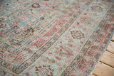 Distressed pile showing visible foundation with faded powder blue and raspberry floral patterns.
