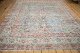 Distressed Meshed carpet section with faded powder blue and blush floral patterns, showing wear.
