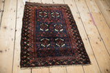Full view of an antique Belouch rug highlighting its cypress tree and pawn design motifs.