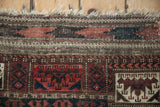 Low pile revealing knot heads on the pictorial panel border and tattered fringe.