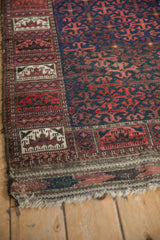 Tattered corner of an antique Belouch rug showing the unique pictorial panel border.