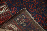 The hand-knotted wool foundation and worn side of an antique Belouch rug corner.