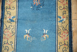 Hand-knotted antique Peking runner detail: two saffron and rose butterfly motifs on sky blue.