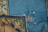 Detailed view showing the hand-knotted foundation and tattered side of the antique Peking runner.