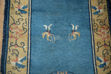 Antique Chinese Peking runner: sky blue field, saffron border, two butterflies, and storied wear.