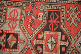 Detailed pattern of vintage Caucasian rug, showcasing geometric Avar motifs in red, brown, and ivory.