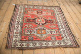 Lower right corner of a vintage Caucasian rug displaying geometric Avar patterns in red, ivory, and mauve.