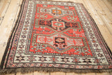 Dark fringe, geometric ivory and mauve borders on a Caucasian rug corner.