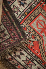 Vintage Caucasian rug corner, displaying chocolate brown fringe and restored side cord selvage.