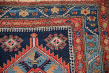 Antique Northwest Persian rug corner with serrated medallion, tomato red vine border, and blue abrashes.