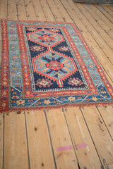 Antique Northwest Persian rug: abrashed sky blue vine border, red inner border, and worn field.