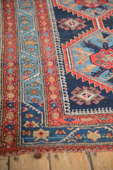 Antique Northwest Persian rug detail showcasing vibrant red border with meandering vine motifs.