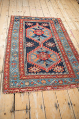 Antique Northwest Persian rug: meandering vine and blossom border, varied blue wave field.