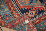 Antique Northwest Persian rug's folded corner, revealing its hand-knotted back, tattered end, and Hamadan provenance tag.