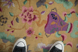 Even, hand-knotted pile of an antique Art Deco rug showing a violet vase and pink floral motifs.