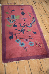 Antique Art Deco rug's cochineal red corner, blue florals, aubergine border, and tattered fringe.
