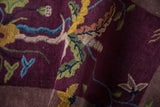 Rich pile texture of an Art Deco rug with aubergine, gold, and celadon pictorial motifs.