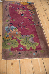 Art Deco runner, pictorial moss green leaves and apricot lotus on mauve field, white knots visible.